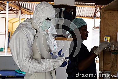 Lunsar, Sierra Leone - April 29,2015: a nurse and medical worker prepare to enter dangerous zone of an ebola treatment center to Editorial Stock Photo