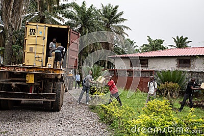 Lunsar, Sierra Leone - June 9, 2015: African community volunteers help unload boxes from a humanitarian aid truck in an African Editorial Stock Photo