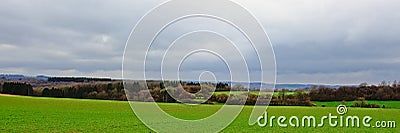 Lush green fields, hills and forests of Ardennes on a misty cloudy day Stock Photo