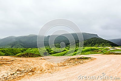 Lush green landscape, trees and foggy mountains in Ayn Khor tourist resort, Salalah, Oman Stock Photo