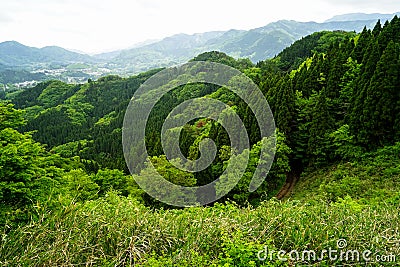 Lush greenery mountain panorama, roadway and town view from afar Stock Photo