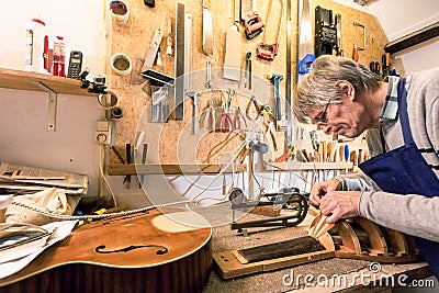 Luthier concentrating on carving a lute Stock Photo