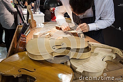 Luthier working on a violin at Bit 2014, international tourism exchange in Milan, Italy Editorial Stock Photo