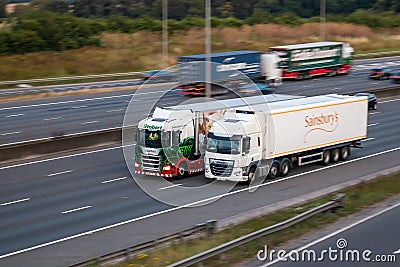 Eddei Stobart lorry and Sainsubrys lorry in motion on British motorway Editorial Stock Photo