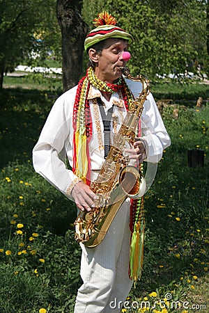 Lutsk, Ukraine - May, 02, 2009: Street musician. The clown plays the saxophone Editorial Stock Photo
