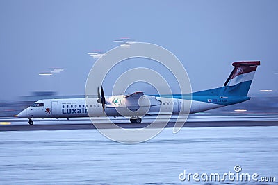 Luxair plane taxiing on runway, snow in winter Editorial Stock Photo