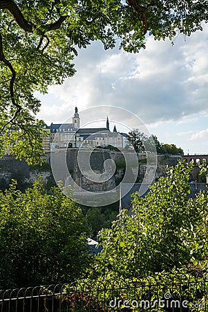 Luxembourg skyline and bridge framed by lush green summer trees Editorial Stock Photo