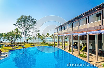 Luxuary hotel and swimming pool against palm trees Stock Photo