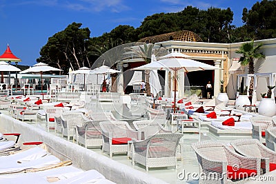 Luxurious beach, white umbrellas by pool. White trendy sun loungers and chairs, beach furniture by sea, Beautiful summer Sibenik, Stock Photo