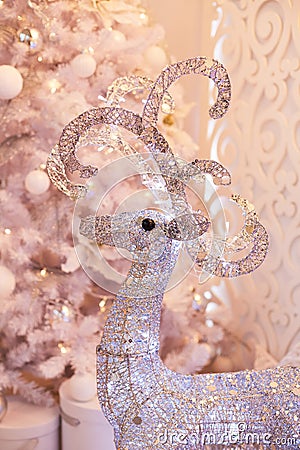 Luxurious bright living room decorated with beautiful white Christmas tree. New year`s interior. Silver stag Stock Photo