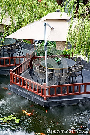 Luxurious Chinese garden restaurant seats and ancient building turret Stock Photo