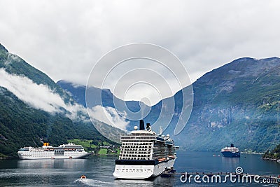 A luxurious cruise ship anchored near a Norwegian fjord village of Flam during the summer months Stock Photo
