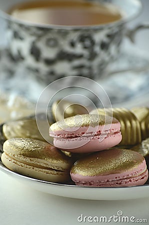 Luxurious gold French macarons and chocolates on a porcelain plate Stock Photo