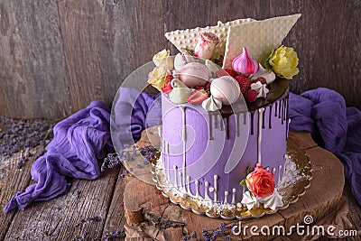 Luxurious Purple cake decorated with a bise, marshmallow, berries and fresh flowers. Stock Photo
