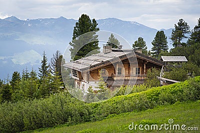 Luxurious wooden chalet house on austrian mountains alps between trees Stock Photo