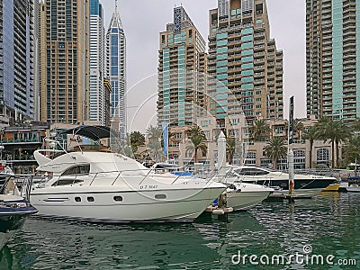 Luxurious Yachts in Front of Dubai Marina Futuristic Skyscrapers in cloudy rainy day. Editorial Stock Photo