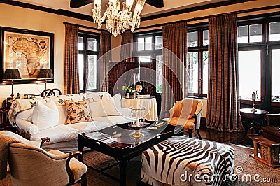 Luxury African Safari lodge living room interior with old vintage armchairs sofa couch and tribal style ornaments Editorial Stock Photo