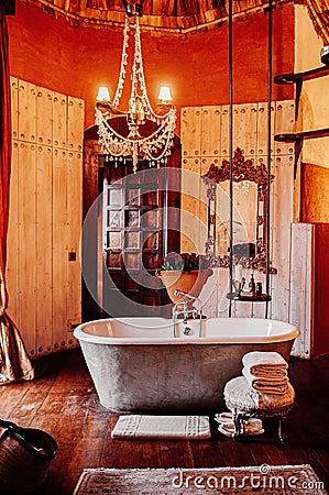 Luxury African tribal hut bathroom interior decoration with old vintage bathtub and chandelier Editorial Stock Photo