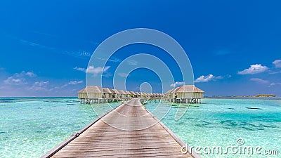 Maldives island, luxury water villas resort and wooden pier. Beautiful sky and clouds and beach background for summer vacation Stock Photo