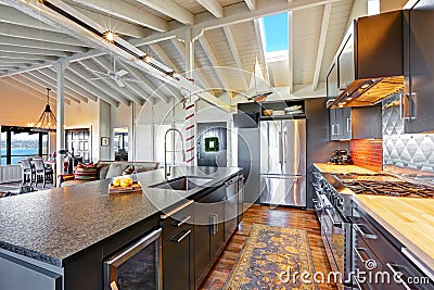 Luxury beautiful dark modern kitchen with vaulted wood ceiling. Stock Photo