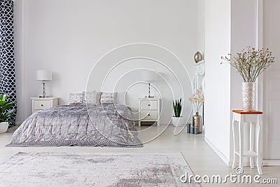 Luxury bedroom interior design with silver duvet and pillows on kind size bed, real photo with copy space Stock Photo