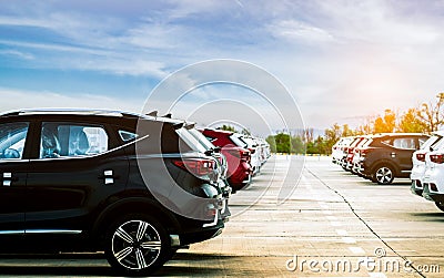 Luxury black, white and red new suv car parked on concrete parking area at factory with blue sky and clouds. Car stock for sale. Stock Photo