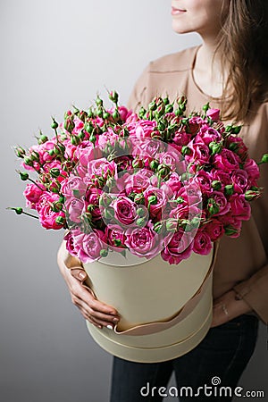 Luxury bouquets of flowers in the hat box. roses in the hands women. Pink Colour peonies Stock Photo