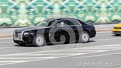 luxury car Rolls-Royce Ghost driving down the road at high speed Editorial Stock Photo