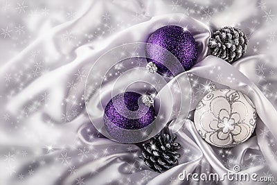 Luxury Christmas balls Silver pine cones on white satin Christmas decoration combined purple and silver colors. Stock Photo