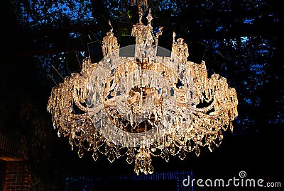 Luxury crystal chandelier shining on dark background. Stock Photo