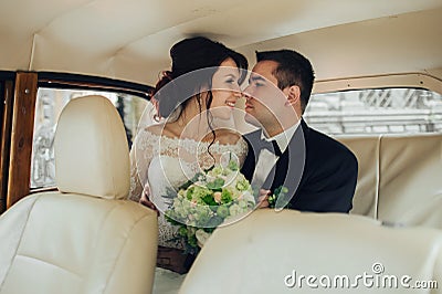 Happy stylish newlywed couple posing in retro car Stock Photo