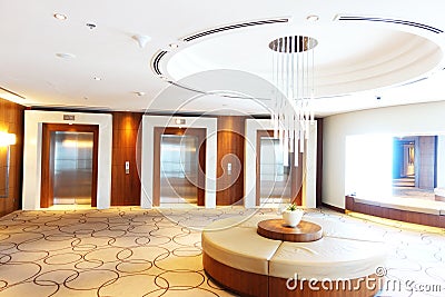 Luxury hotel lobby or hall with three modern elevators and glass chandelier in the middle Stock Photo