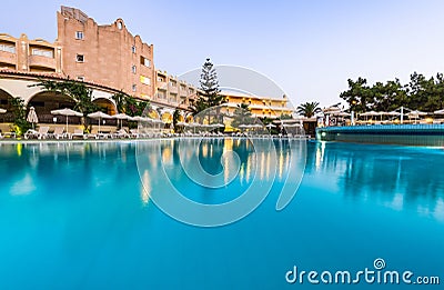 Luxury Hotel Resort with Swimming Poll Illuminated at Sunrise Stock Photo