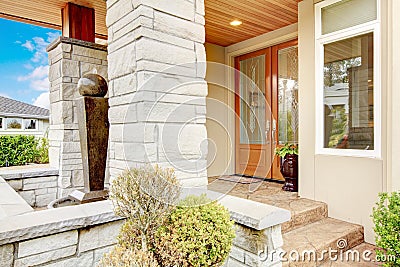 Luxury house entrance porch with stone column trim and stained w Stock Photo