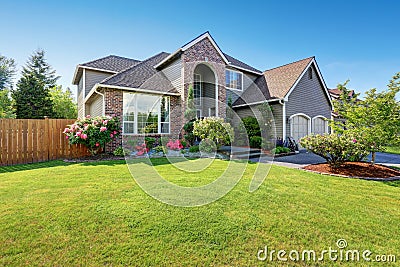 Luxury house exterior with brick and siding trim and double garage. Stock Photo