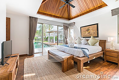 Luxury Interior design in bedroom of pool villa with cozy bed with high raised ceiling in the house or home building Stock Photo