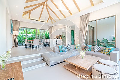 Luxury interior design in living room of pool villas. Airy and bright space with high raised ceiling, sofa, middle table, dining Stock Photo