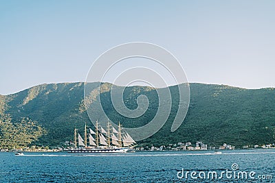 Luxury large sailboat sails on the sea along the mountainous coast Stock Photo