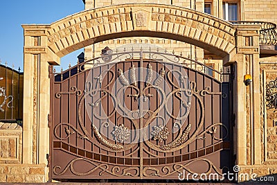 Luxury metal wrought iron gates and a stone arch for the entrance to a private house Stock Photo