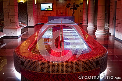 Luxury plunge pool in the centre of the column design spa. A filled spa pool in a pillared hall of dainty sauna. Indoor aquazone Stock Photo