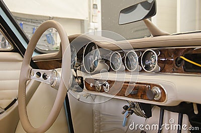 Luxury Race Retro Car Interior With Beige Finish. Speedometer And Tachometer On Dashboard. Car In Workshop Stock Photo