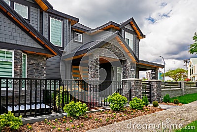 Luxury residential house with front yard behind metal fence Stock Photo