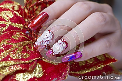 Luxury sparkling red color gel polish painting 3D rose flower decorate d with shiny rhinestone and glitter on fashionista woman Stock Photo