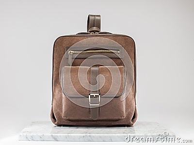 Luxury suet backbag. Luxury brown leather and suet backpack on white background, on marble floor. Stock Photo