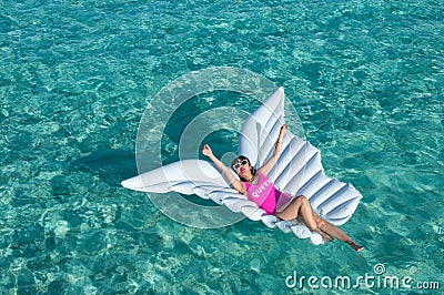 Luxury summer vacation beach woman relaxing lying down on inflatable pool float floating at Maldives sun tanning. Model sleeping o Stock Photo