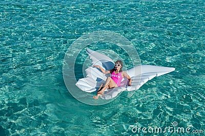 Luxury summer vacation beach woman relaxing lying down on inflatable pool float floating at Maldives sun tanning. Model sleeping o Stock Photo