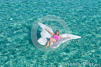 Luxury summer vacation beach woman relaxing lying down on inflatable pool float floating at Maldives sun tanning. Model sleeping o Stock Photo