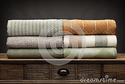 6 luxury throws, folded up and shot on a wooden sideboard, with a grey background Stock Photo