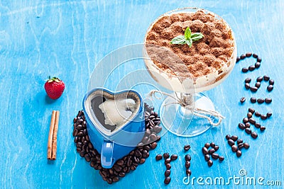 Luxury tiramisu dessert in a cocktail glass decorated with cocoa and mint. Concept i love tiramisu, blue, top view Stock Photo