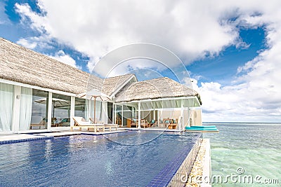 Luxury water villa with infinity pool and terrace overlooking sea bay in Maldives islands Stock Photo